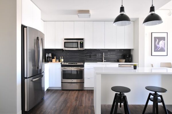 Apartment unit kitchen after a multifamily renovation with white cabinets and stainless appliances